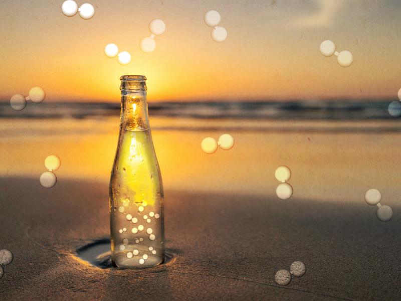 Bottle on a beach with hydrogen molecules in the background