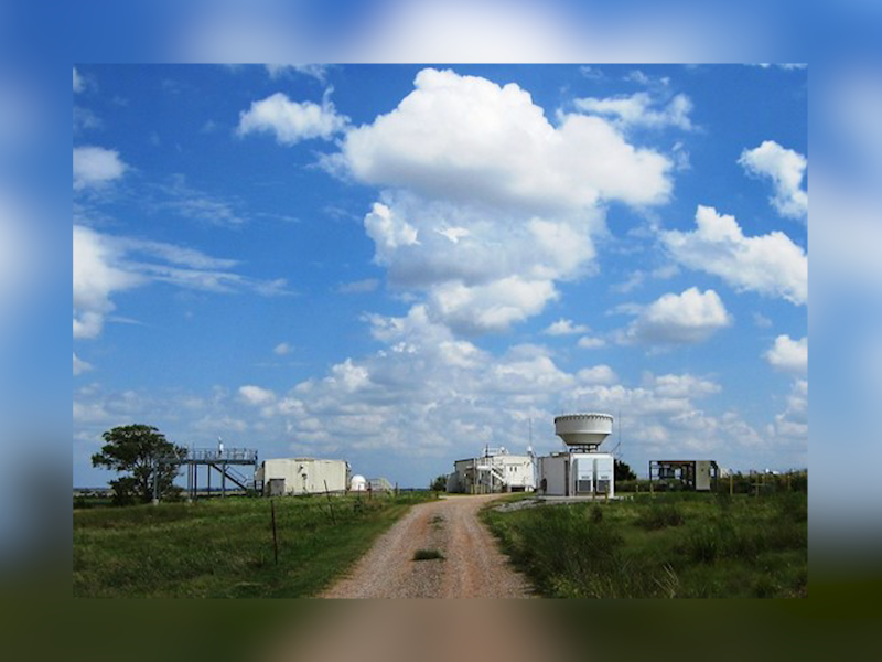 A photograph of measurement facilities with a blue sky and white puffy clouds above