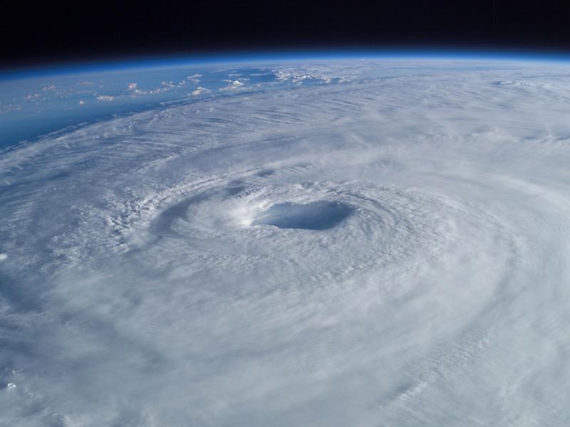 This image depicts a hurricane from above, clouds encircling as they form the storm.